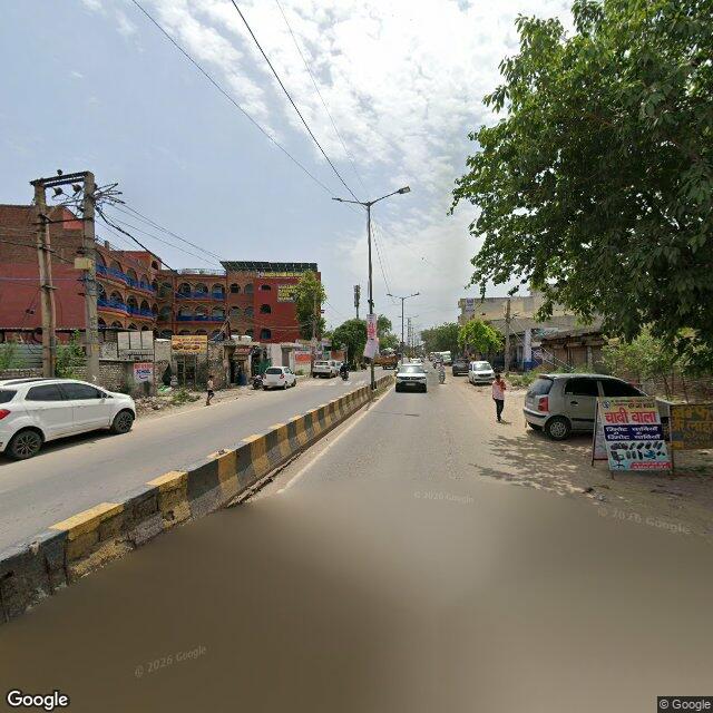 Along the street, away from the gate