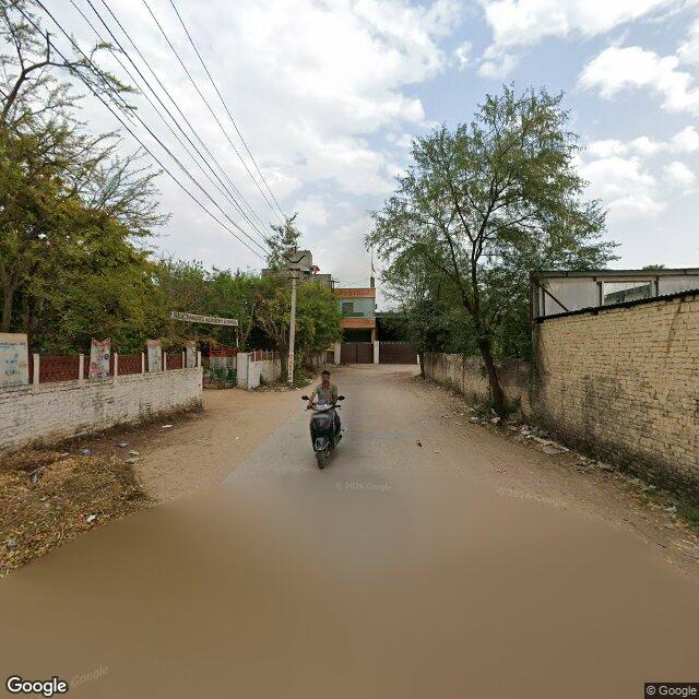 The frontage road, along the school wall