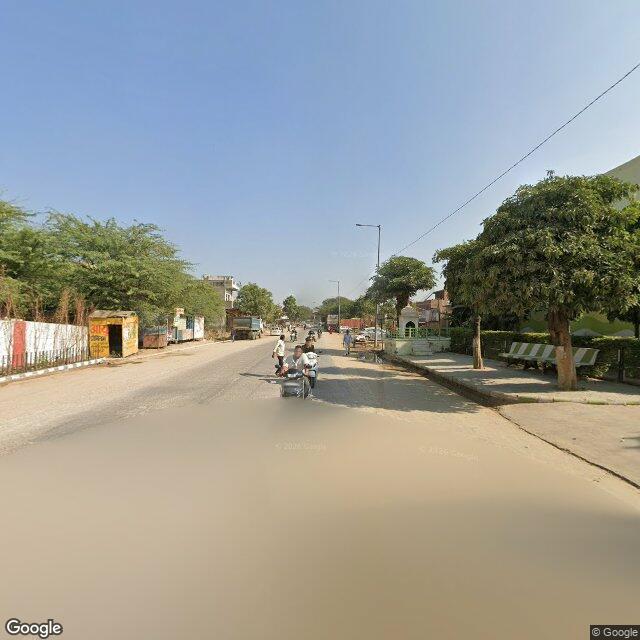 The frontage road, along the school wall