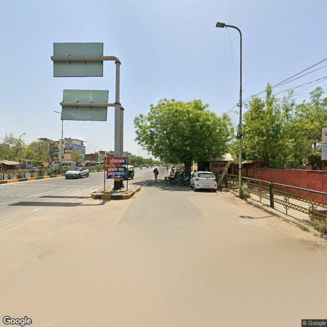 Along the street, away from the gate