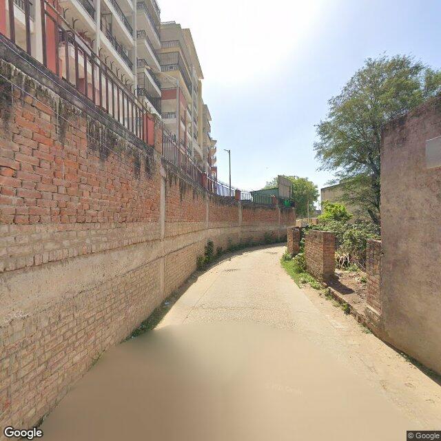 Along the street, away from the gate