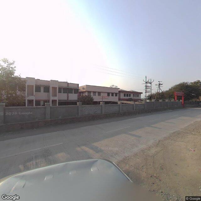 The frontage road, along the school wall