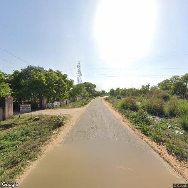 The frontage road, along the school wall