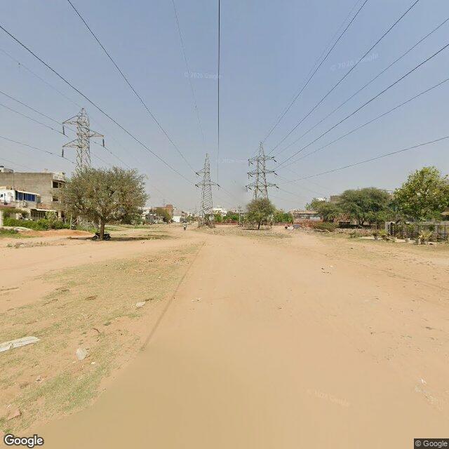The frontage road, along the school wall