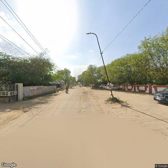 The frontage road, along the school wall