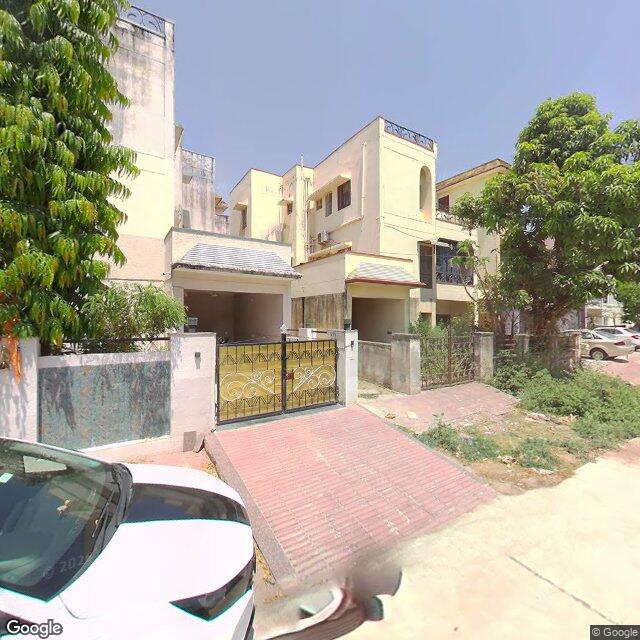 Along the street, away from the gate