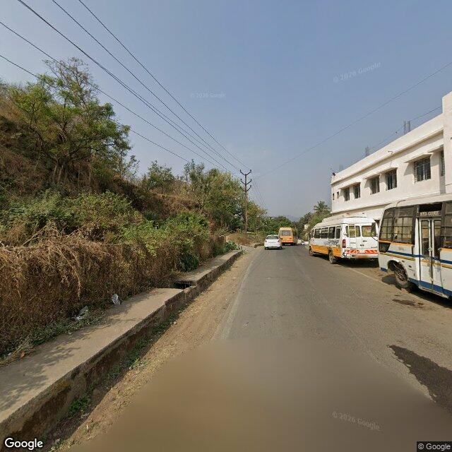 The frontage road, along the school wall