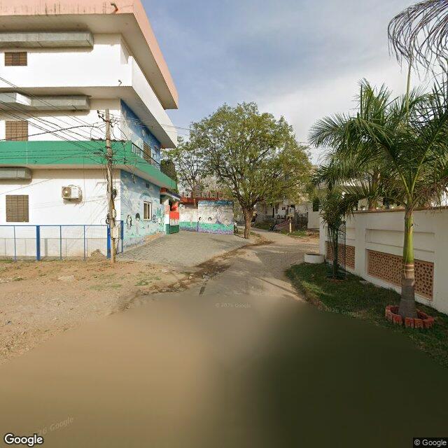 The frontage road, along the school wall