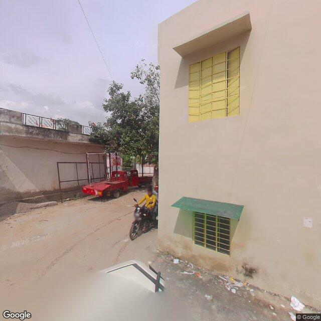 The frontage road, along the school wall