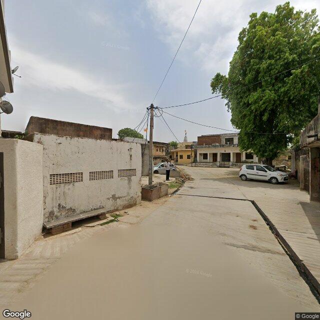 The frontage road, along the school wall