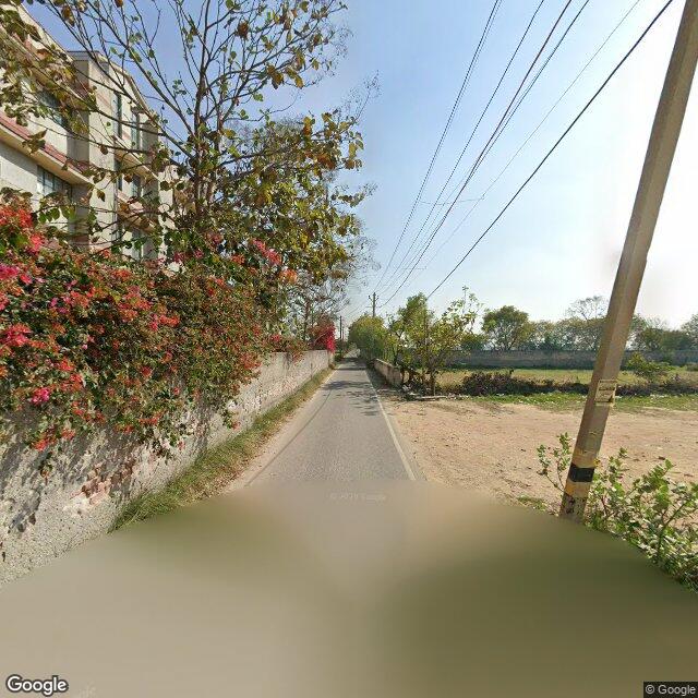 The frontage road, along the school wall