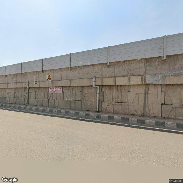 The frontage road, along the school wall