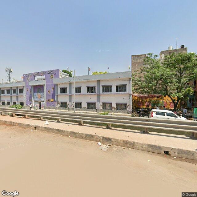 The frontage road, along the school wall