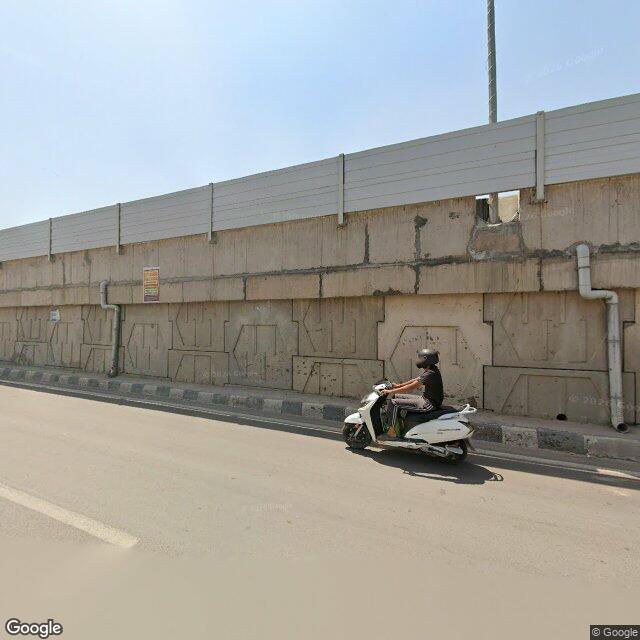 The frontage road, along the school wall