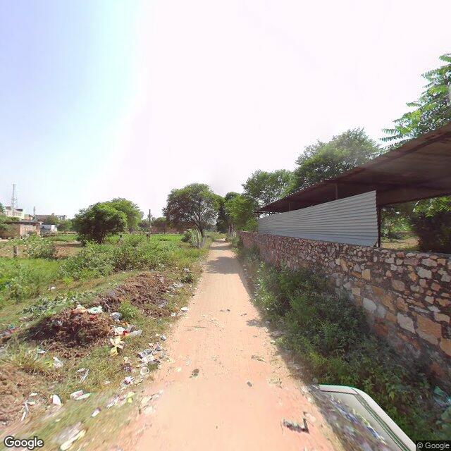 Along the street, away from the gate