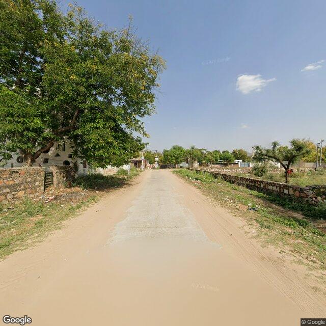 Along the street, away from the gate