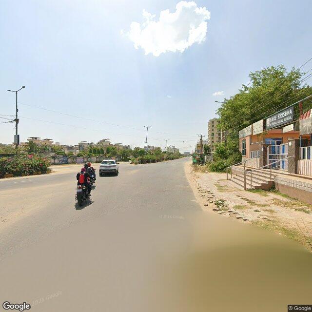 The frontage road, along the school wall