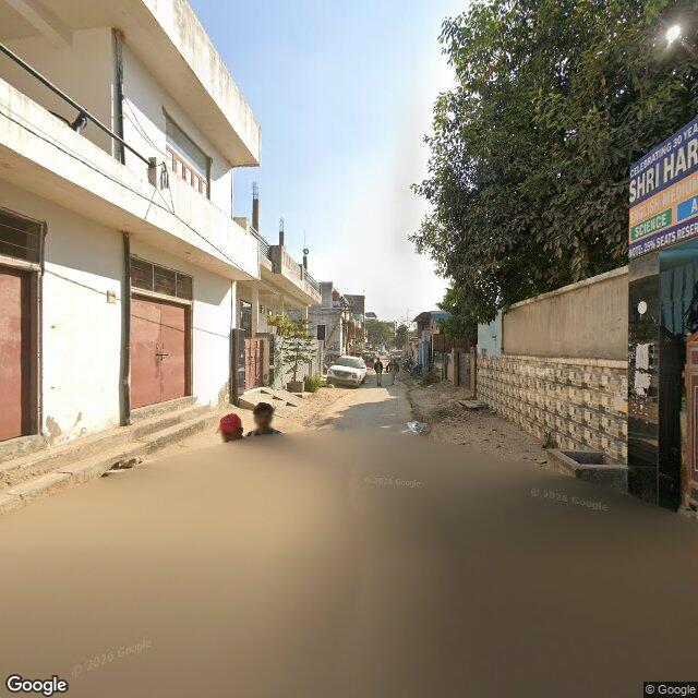 The frontage road, along the school wall