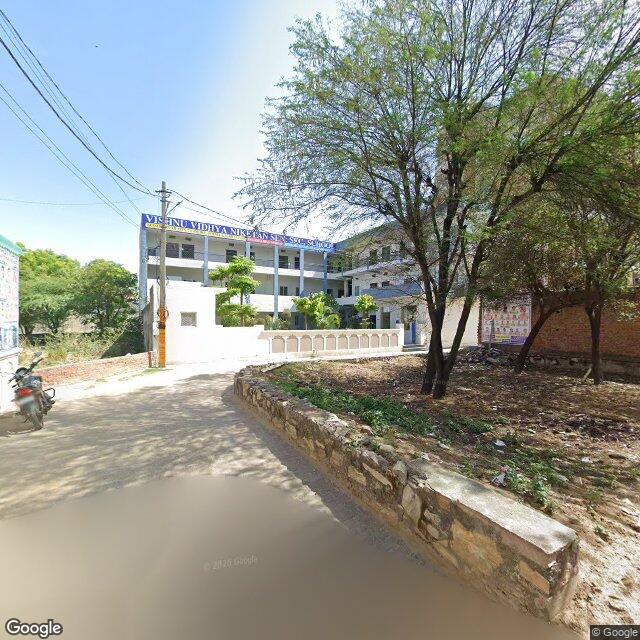 The frontage road, along the school wall