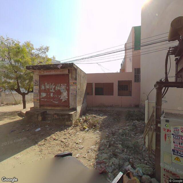Along the street, away from the gate