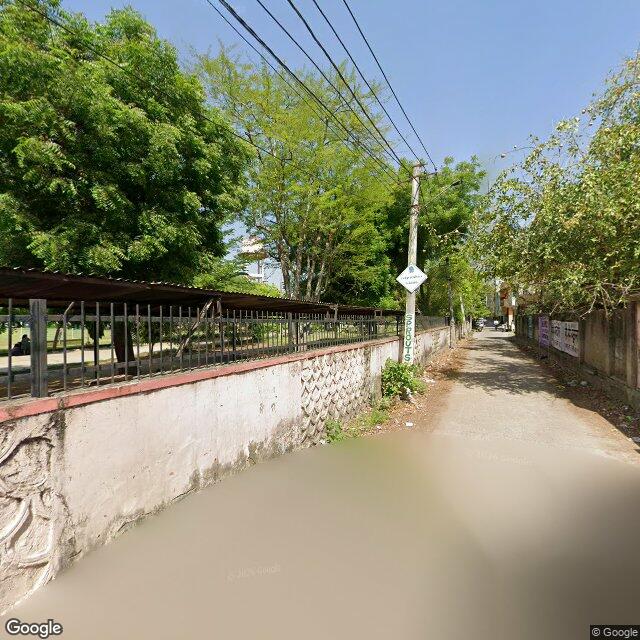 The frontage road, along the school wall