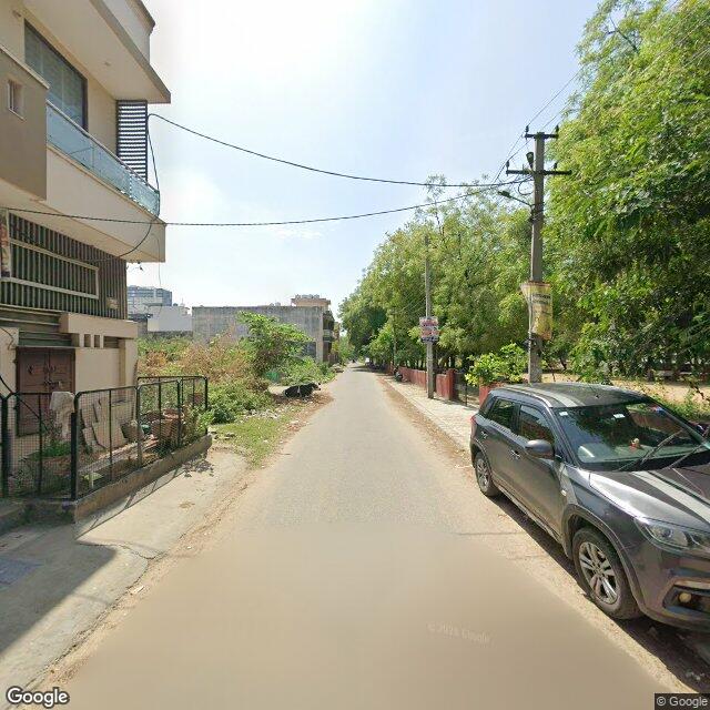 Along the street, away from the gate