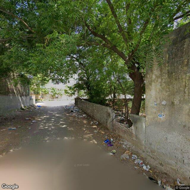 Along the street, away from the gate