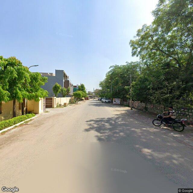 Along the street, away from the gate