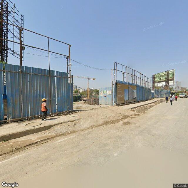 Along the street, away from the gate