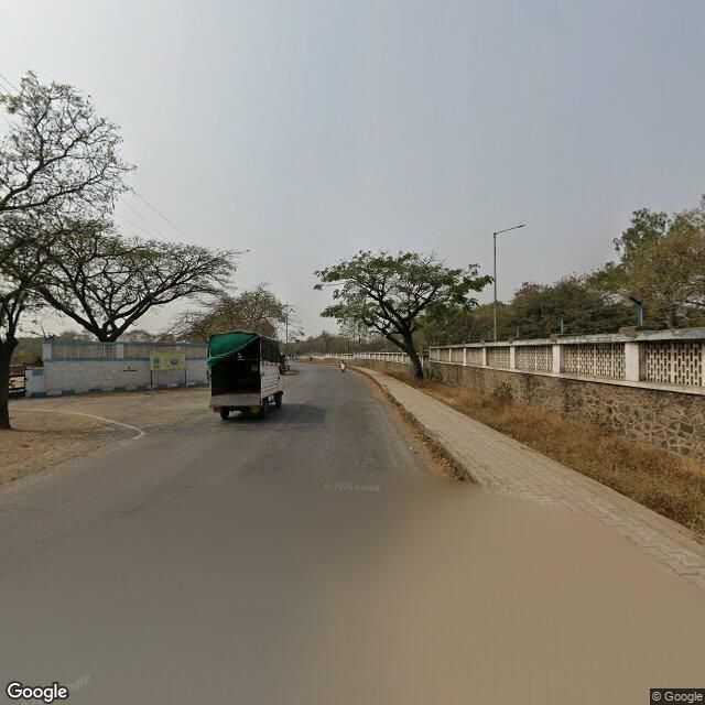 The frontage road, along the school wall
