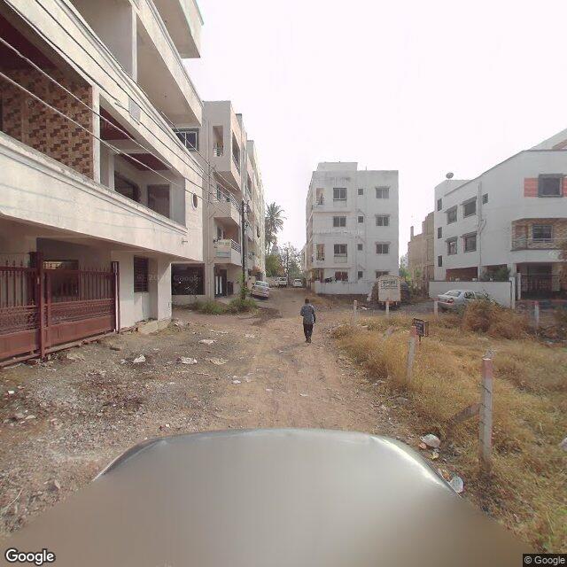 Along the street, away from the gate